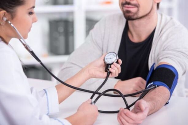 médico mide la presión arterial en la hipertensión